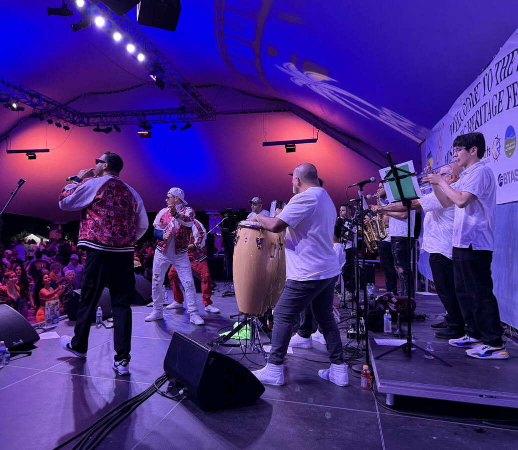 Puerto Rican musicians performing on stage under colorful lights