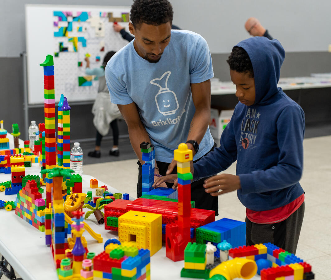Man and child building colorful blocks together