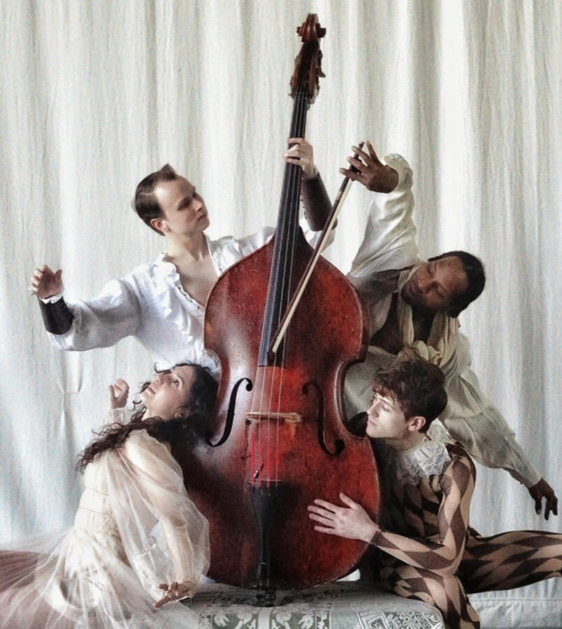 Dancers from Dayton Dance Initiative posed artistically around an upright bass instrument